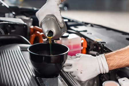 Riverside auto mechanic performing an oil change service